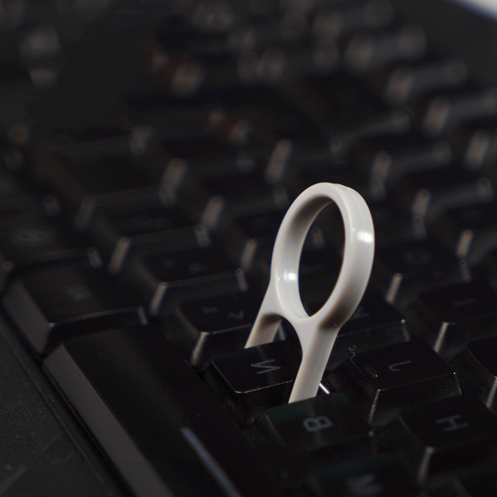 White keycap puller on a black keyboard
