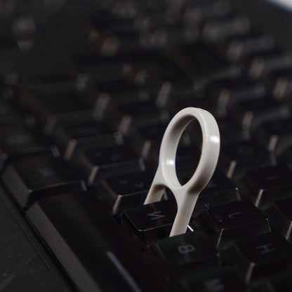 White keycap puller on a black keyboard