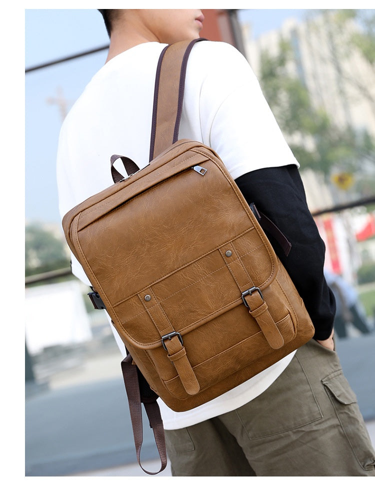 Person wearing a brown backpack outdoors with blurred background